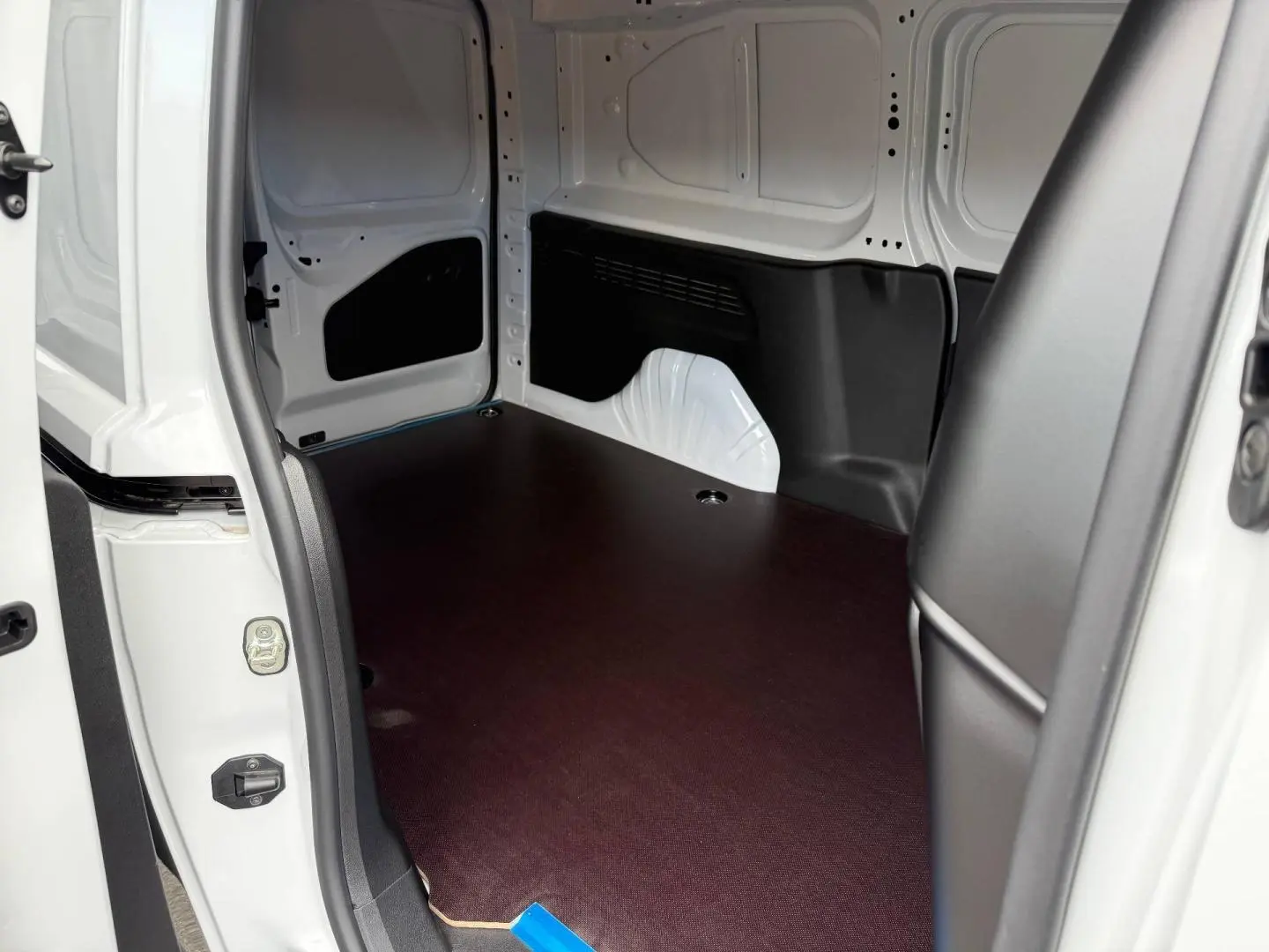 Vue intérieure côté droit du coffre blanc Icy du Citroën Berlingo Fourgon XL Diesel 130ch automatique, avec plancher en bois foncé.