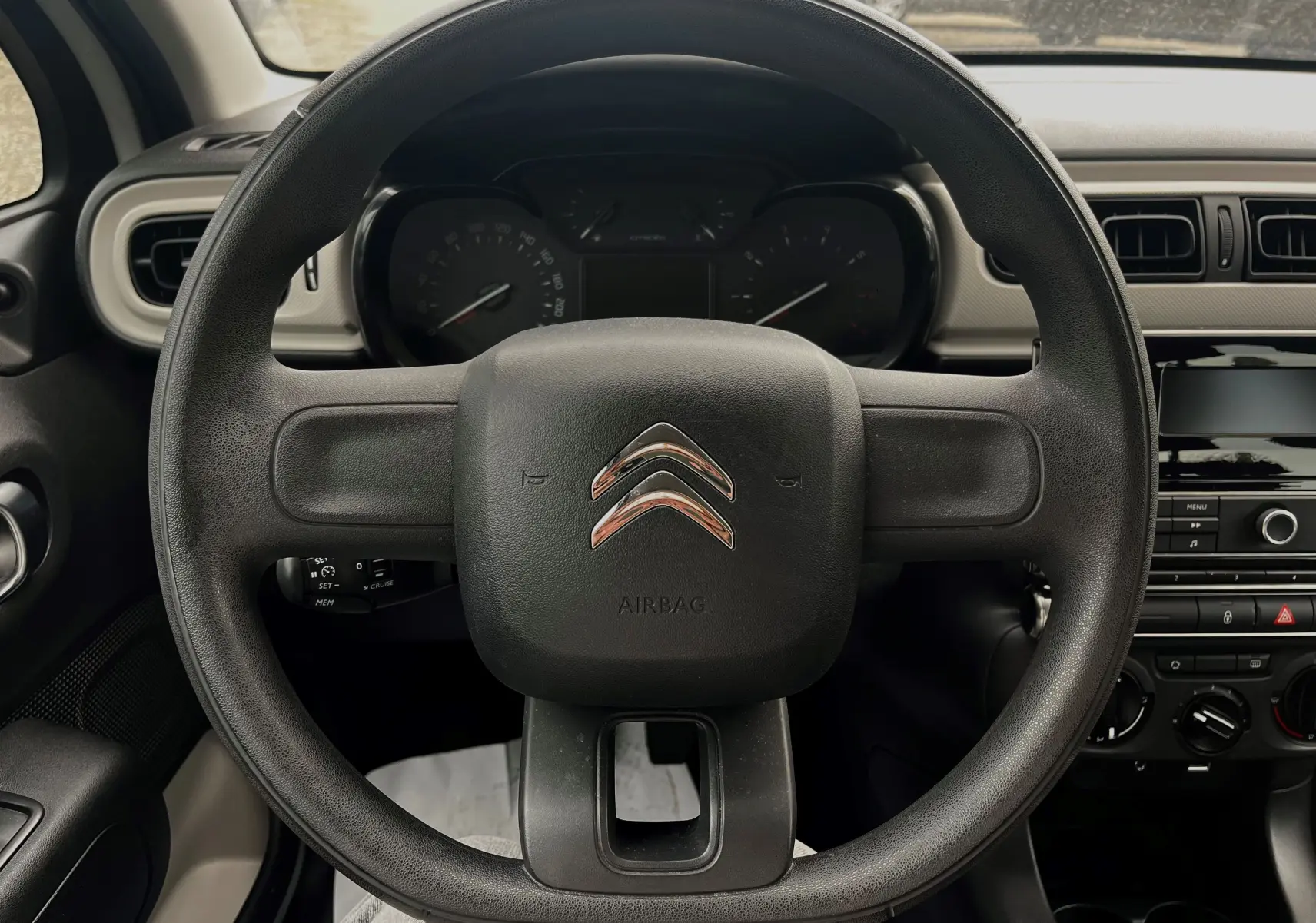 Vue centrée sur le volant noir de la Citroën C3 2017, avec tableau de bord et console centrale visibles en arrière-plan.