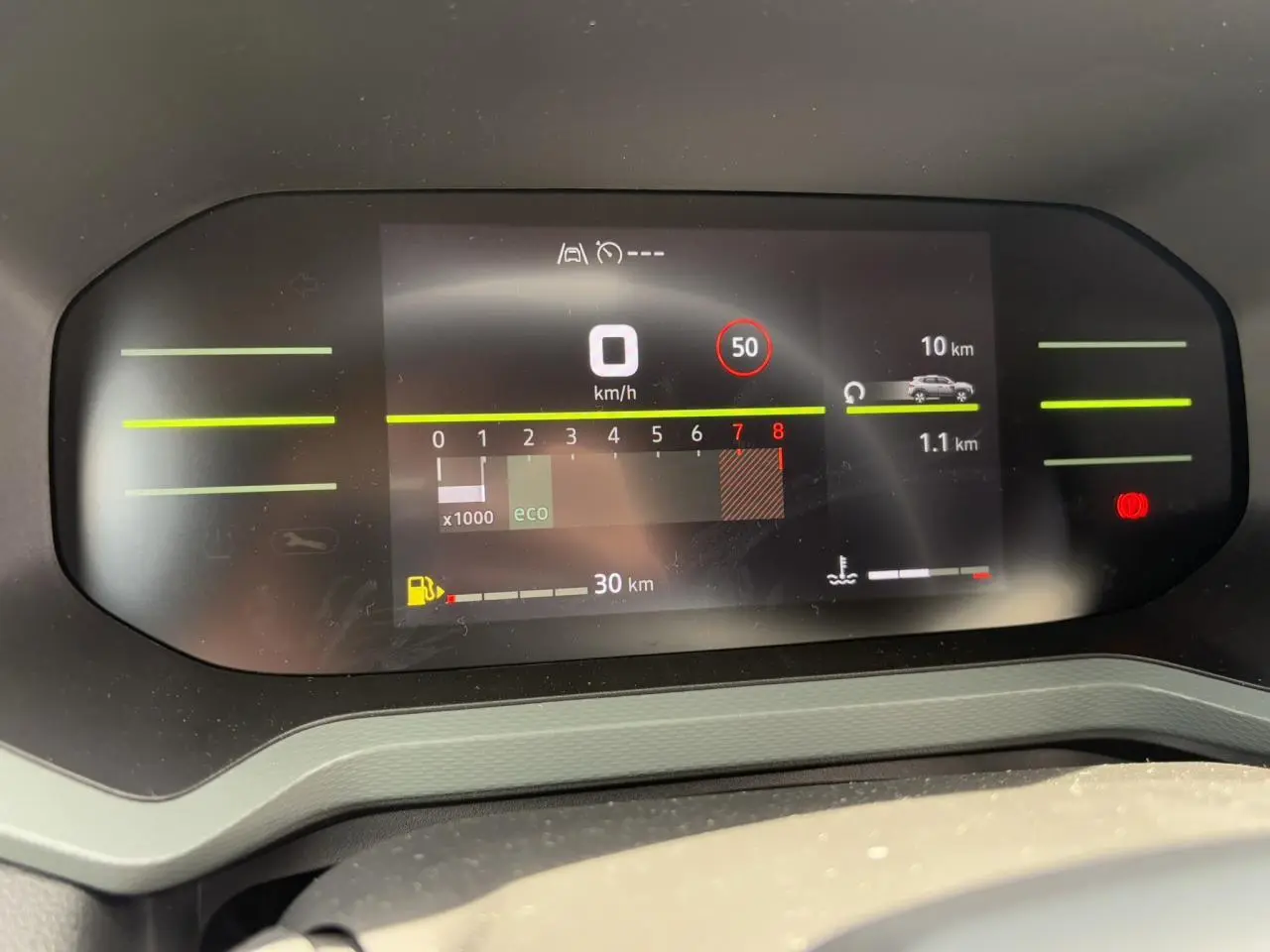 Tableau de bord digital du Dacia Duster 2025 affichant vitesse, régime moteur et autonomie, vue frontale intérieure.