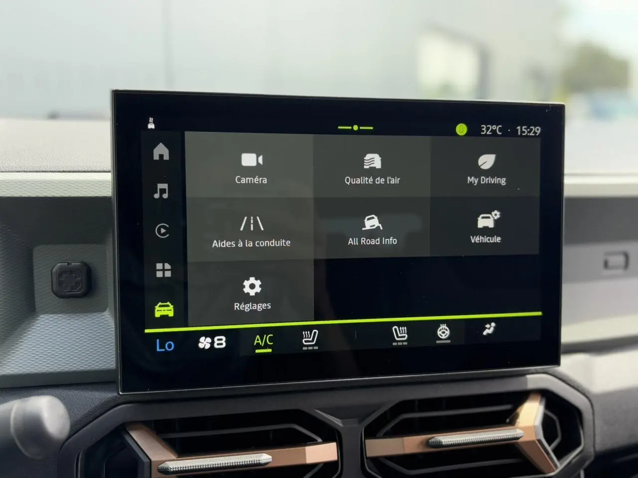 Écran tactile 10 pouces du tableau de bord du Dacia Duster 2025, affichant les réglages de conduite et climatisation