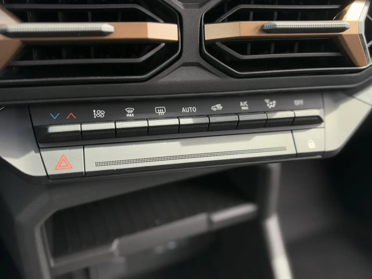 Détail de la console centrale du Dacia Duster 2025 avec commandes climatisation et bouton de verrouillage