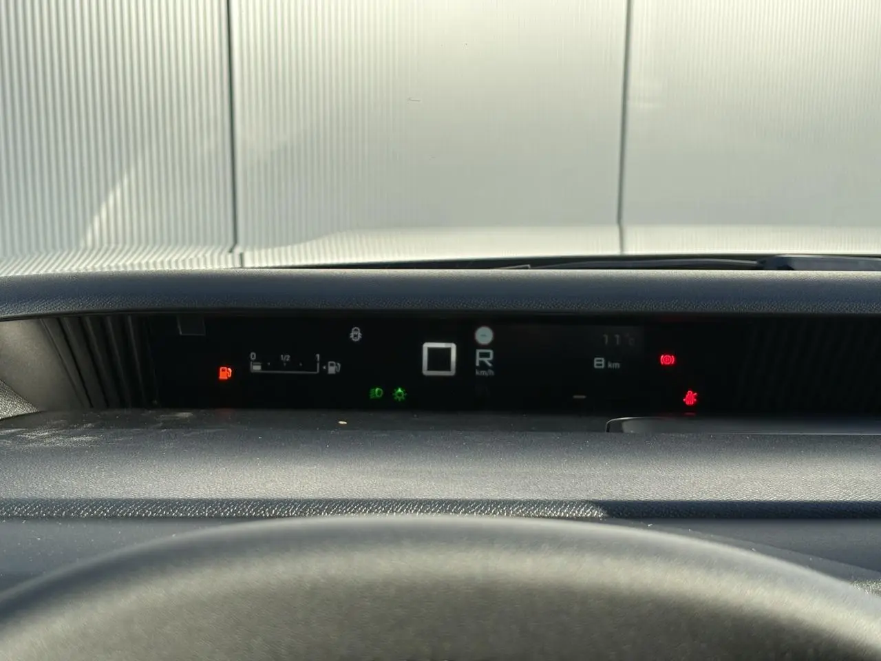 Vue rapprochée du tableau de bord numérique noir du Citroën C3 Aircross Hybrid affichant la vitesse et les alertes.