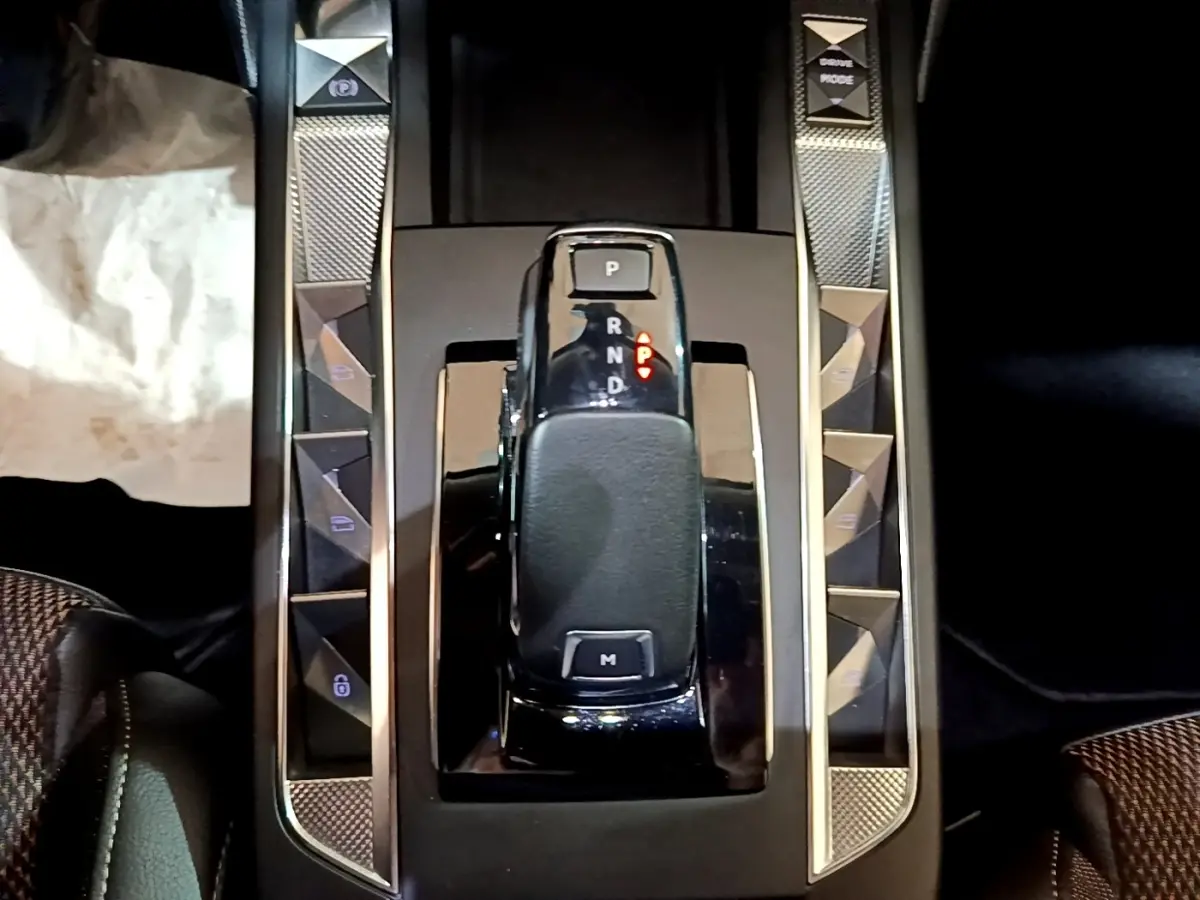Gros plan sur la console centrale noire du DS3 Crossback avec levier de vitesses automatique et boutons de commandes latéraux.