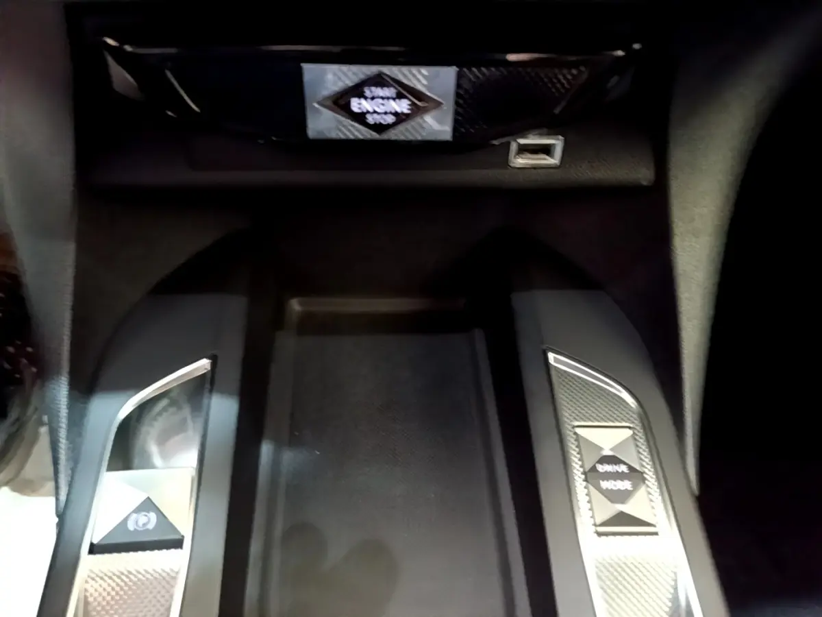 Gros plan sur la console centrale noire du DS3 Crossback avec boutons frein électrique et mode de conduite.