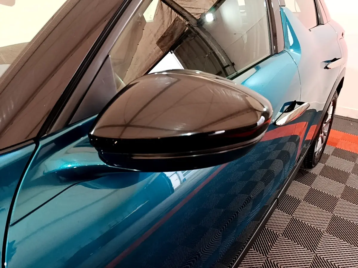 Gros plan sur le rétroviseur côté gauche du DS3 Crossback bleu, avec reflet et partie de la portière visible.
