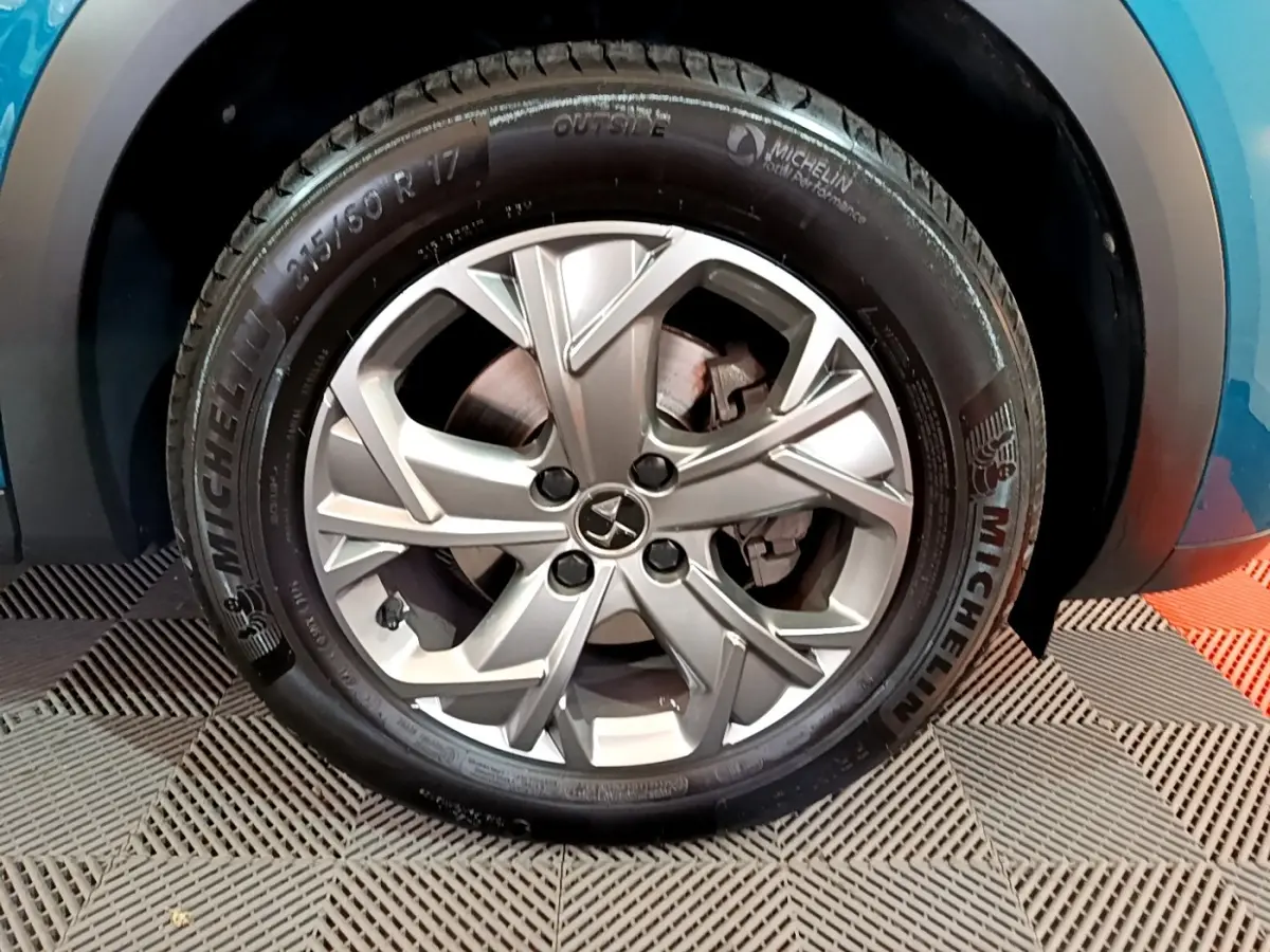 Gros plan sur la roue avant droite avec jante alliage argentée du DS3 Crossback bleu visible en arrière-plan.
