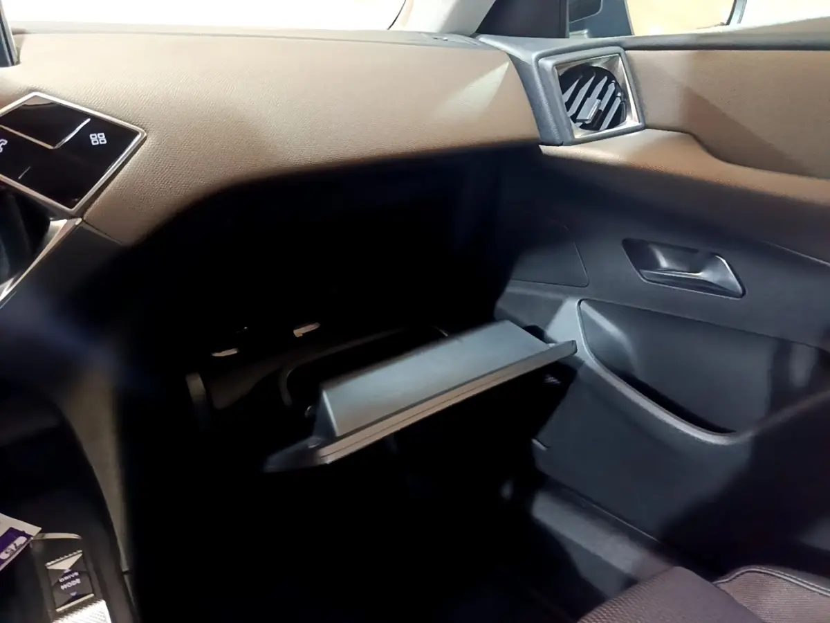 Intérieur du DS3 Crossback bleu, vue côté passager avec boîte à gants ouverte et tableau de bord beige.