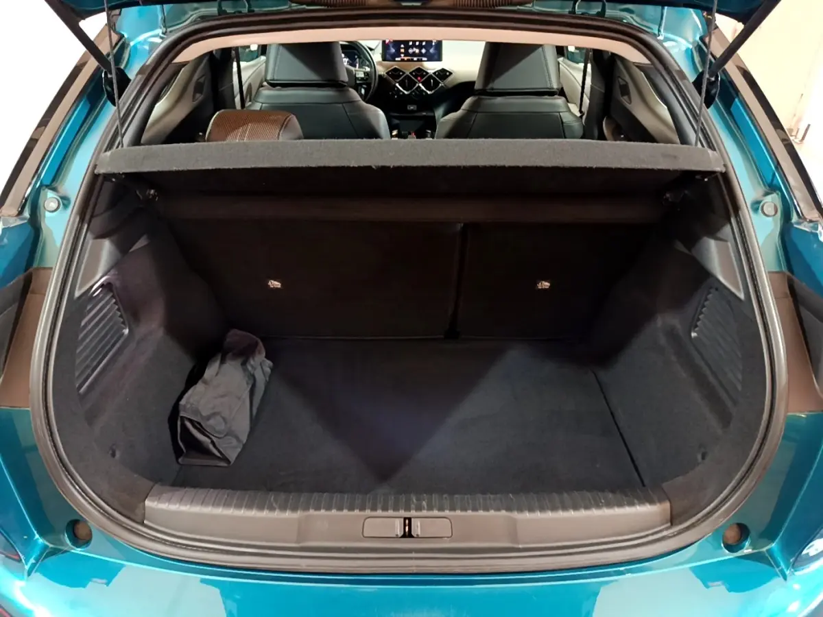 Coffre ouvert vu de l'arrière d'un DS3 Crossback bleu, avec tablette cache-bagages et intérieur noir visible.