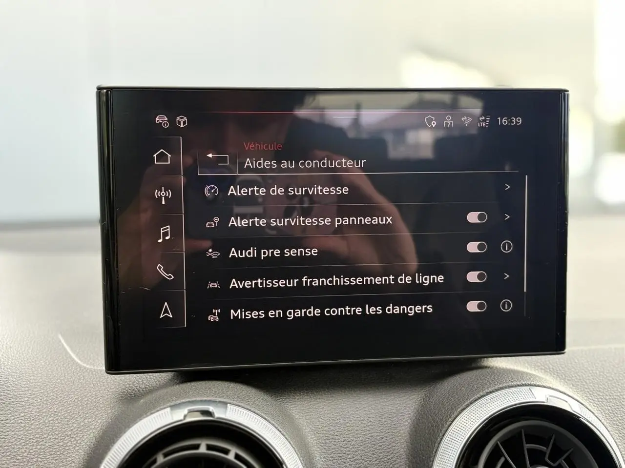 Écran central de l’Audi Q2 35 TDI 150 S-Tronic S-Line affichant les aides à la conduite avec options activables.