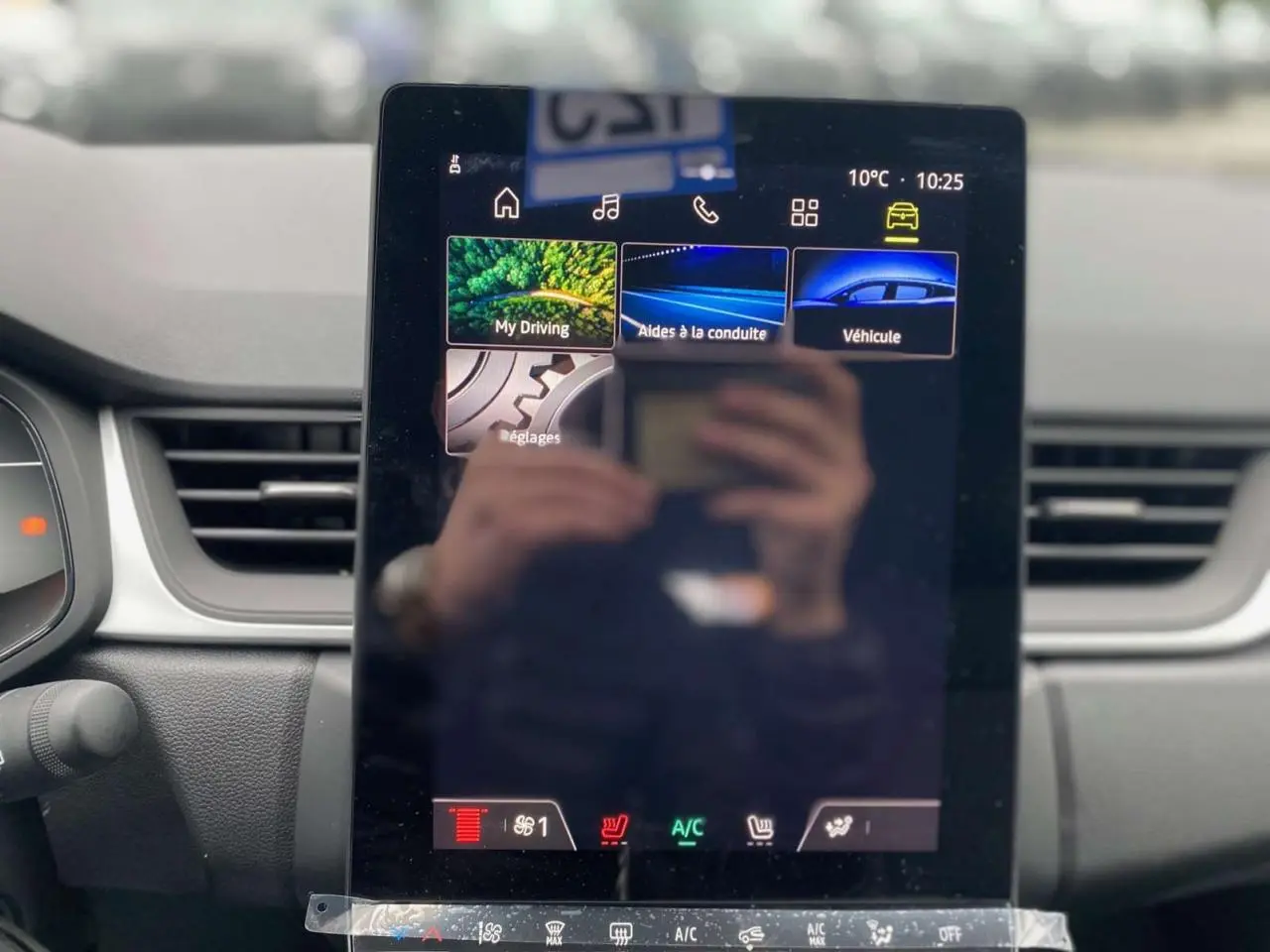 Écran tactile central du tableau de bord du Renault Captur 2025 avec interface multimédia et commandes climatisation visibles.