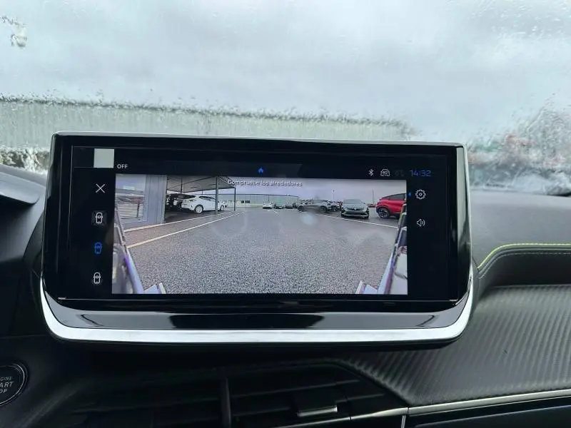 Vue intérieure du tableau de bord du Peugeot 2008 gris 2025, écran affichant la caméra de recul sous la pluie.