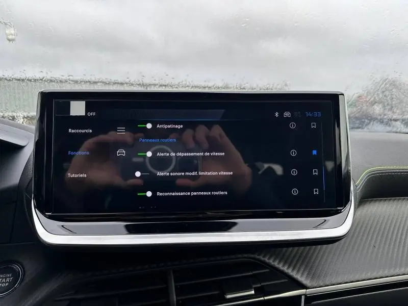 Écran tactile central du tableau de bord du Peugeot 2008 gris 2025 affichant les réglages d’aides à la conduite.