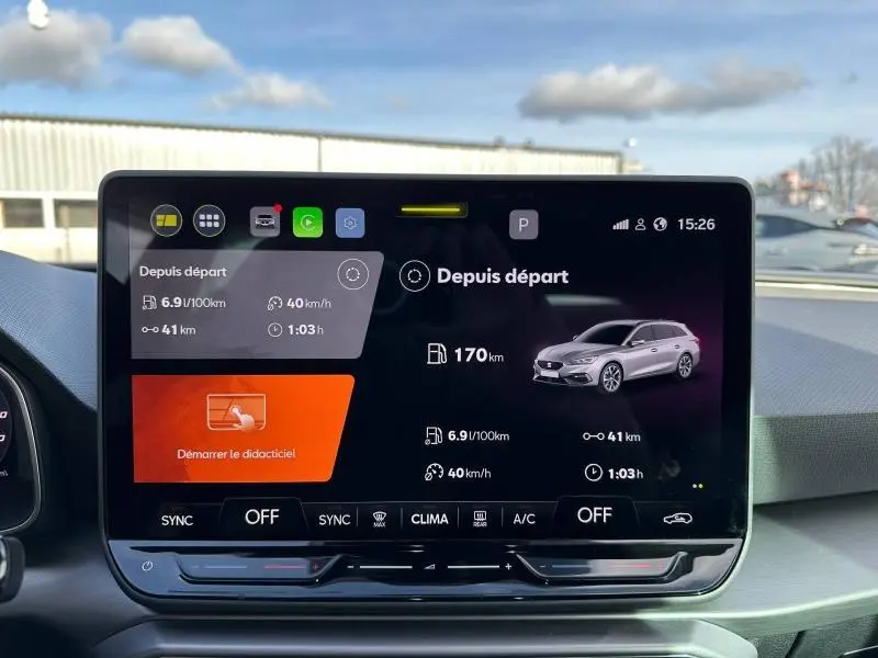 Écran tactile central du tableau de bord montrant l'interface de conduite d'une SEAT LEON ST noire, vue intérieure frontale.