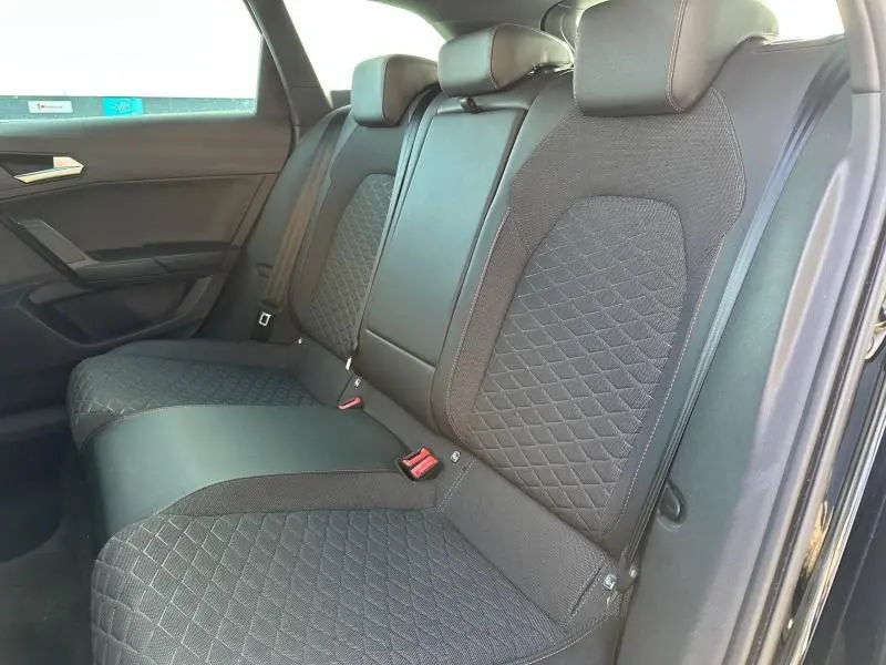 Vue intérieure côté droit des sièges arrière en tissu noir avec surpiqûres, dans une SEAT LEON ST 1.5 eTSI Hybrid 2025.
