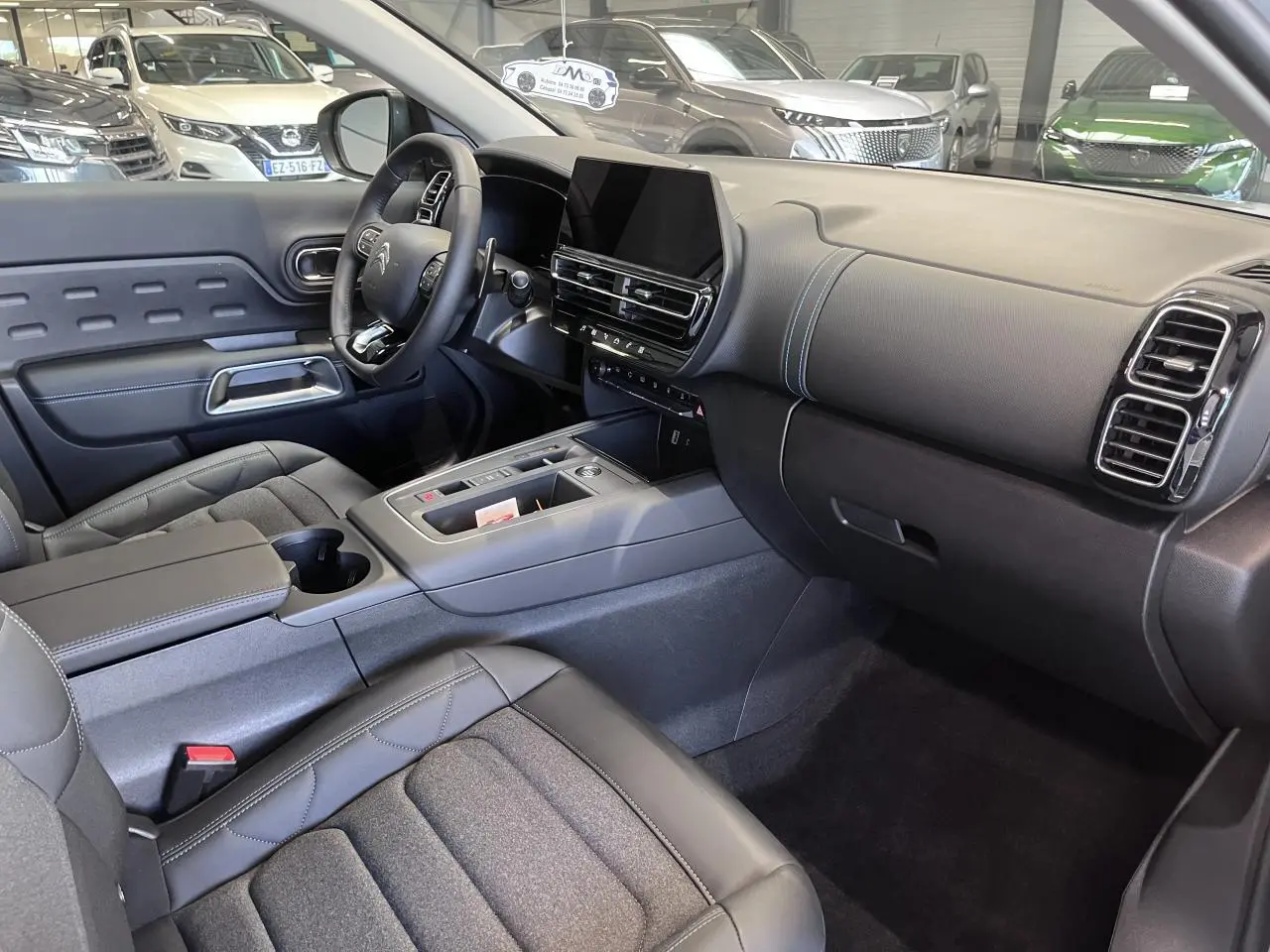 Intérieur avant du Citroën C5 Aircross gris platinium, avec tableau de bord moderne et sièges Advanced Comfort noirs.
