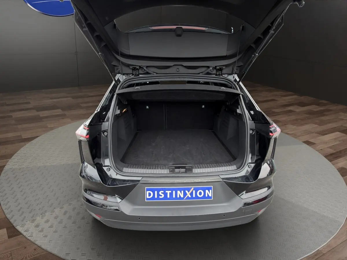 Vue arrière du coffre ouvert du Renault SYMBIOZ noir, mettant en valeur l'espace de chargement généreux et la finition soignée.