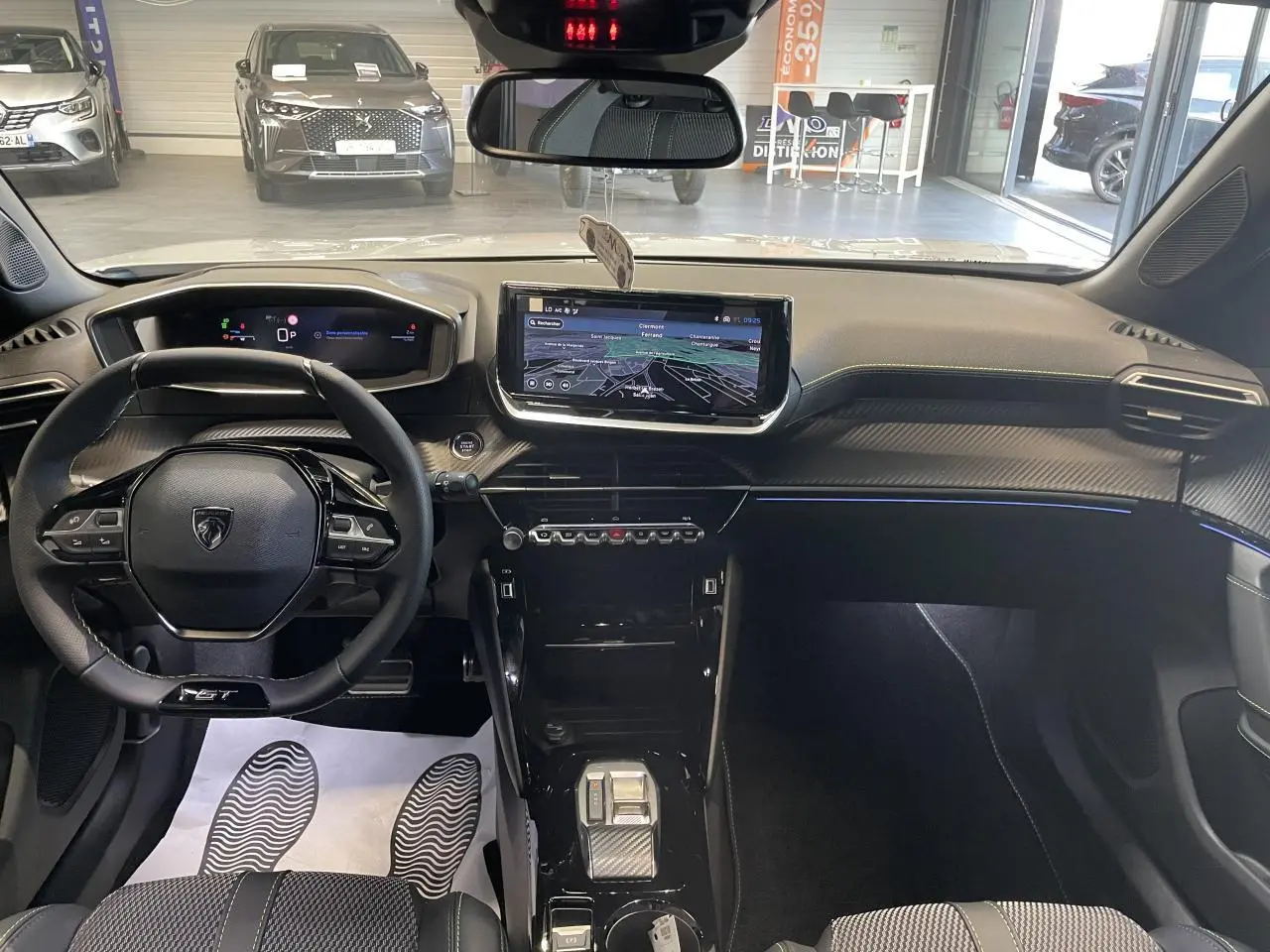 Vue intérieure avant du Peugeot 2008 blanc 2026, tableau de bord avec écran tactile et volant compact cuir noir.