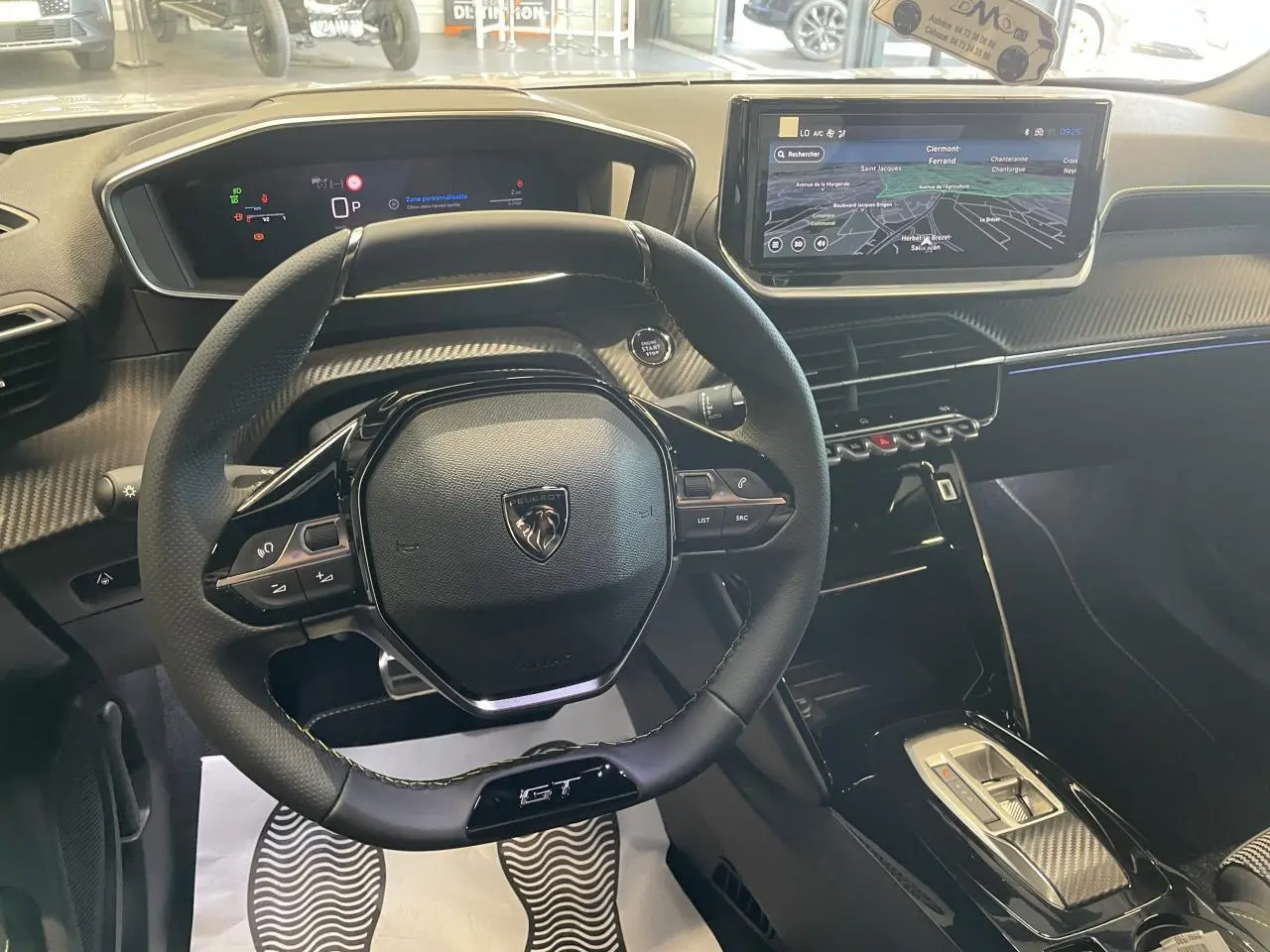 Vue intérieure du poste de conduite du Peugeot 2008 GT 2026, volant compact cuir et écran tactile 10 pouces avec navigation.