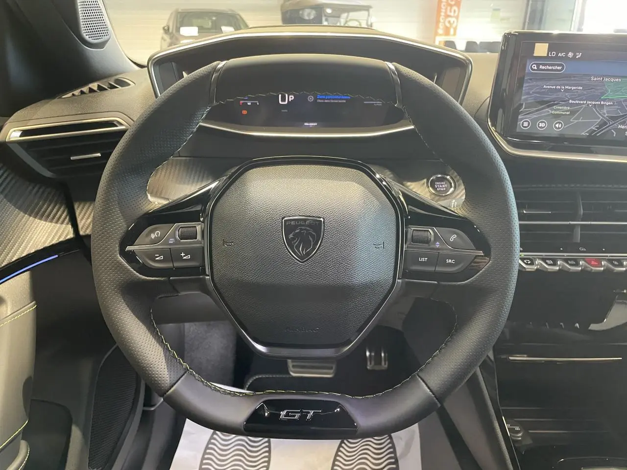 Vue intérieure centrée sur le volant cuir noir GT avec tableau de bord numérique et écran tactile Peugeot 2008 hybride.