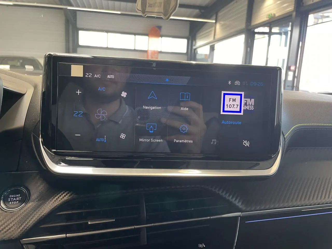 Écran tactile central du tableau de bord du Peugeot 2008 Hybrid avec commandes climatisation et navigation visibles.