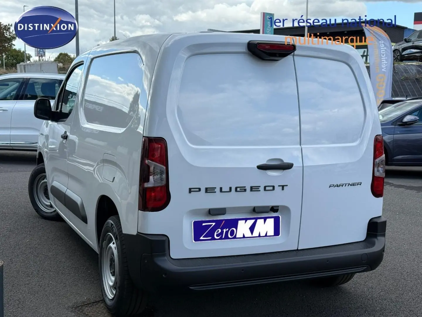 Vue 3/4 arrière droite du Peugeot Partner blanc Icy avec portes arrière battantes et pare-chocs noir.