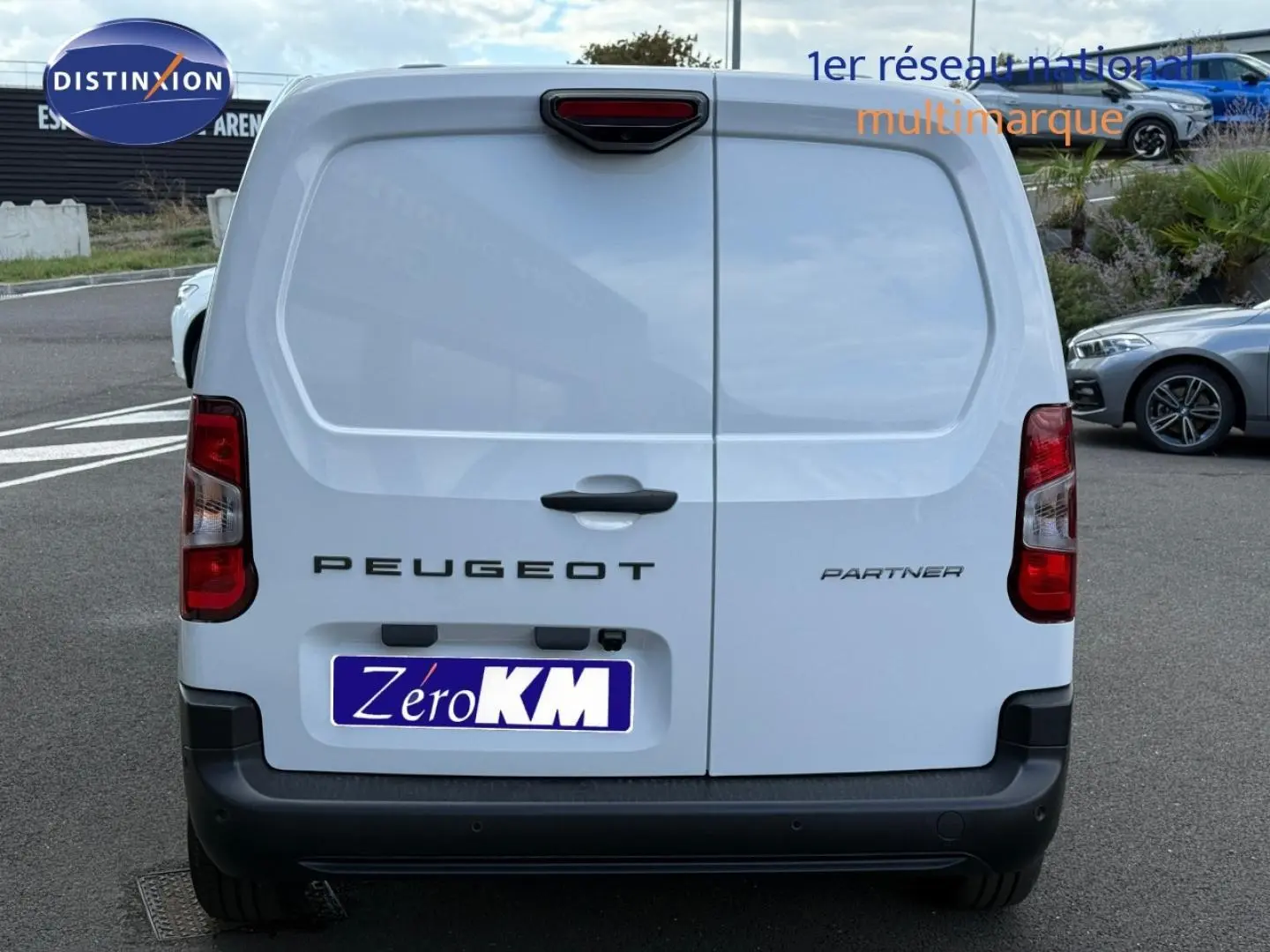 Vue arrière du Peugeot Partner blanc Icy 2026 avec portes battantes et feux arrière rouges distinctifs.