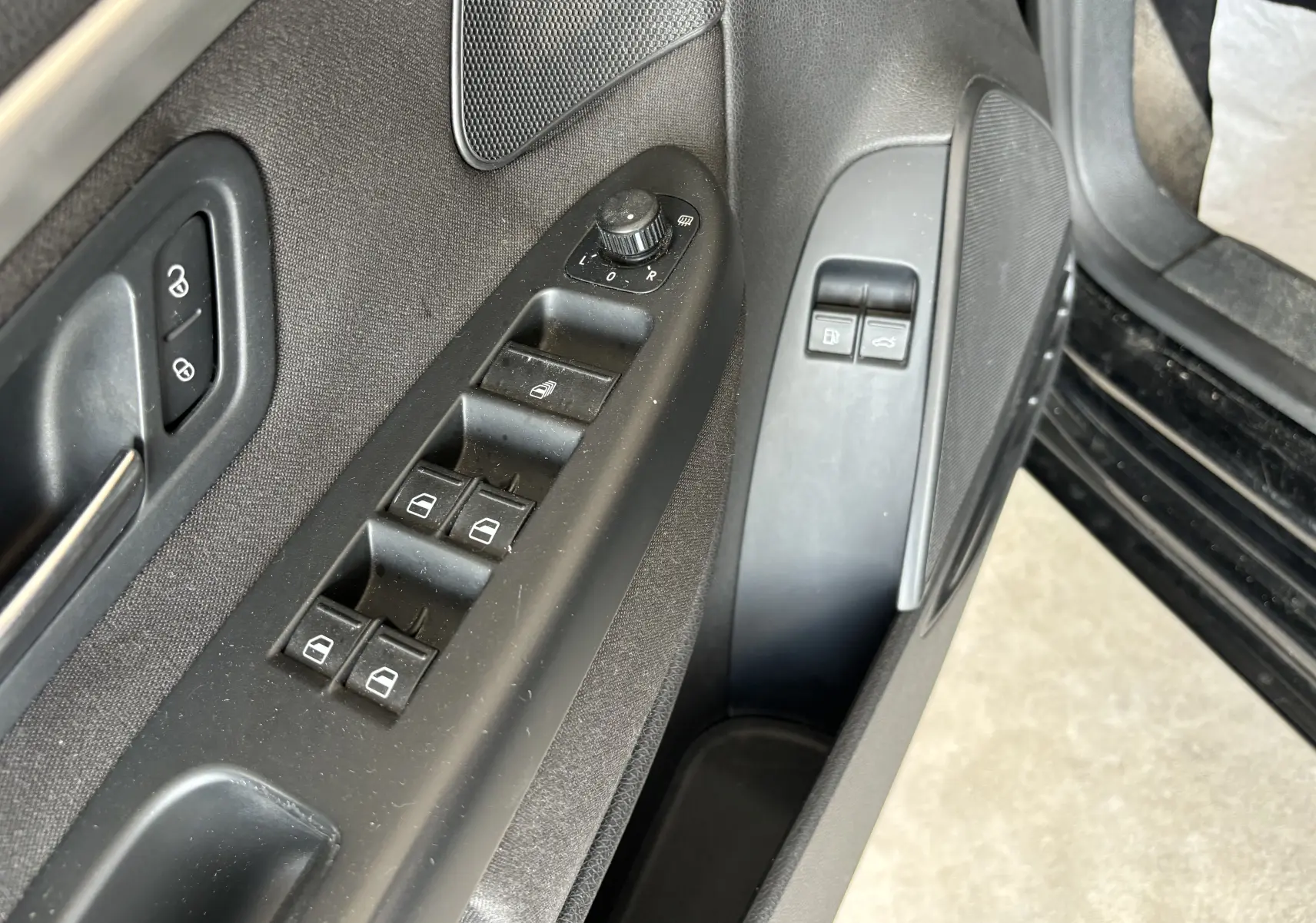 Gros plan sur la commande des vitres et rétroviseurs côté conducteur d'une Volkswagen EOS 2008 en reflet d'argent.