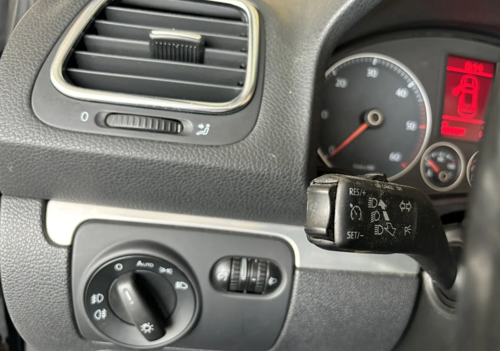 Détail du tableau de bord côté gauche du Volkswagen EOS 2008 avec commandes d'éclairage et levier de régulateur de vitesse.