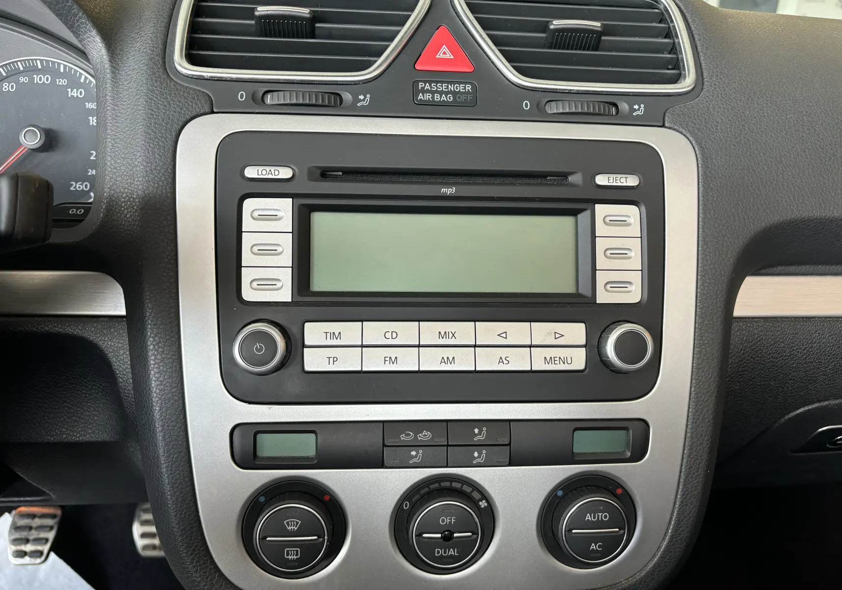 Tableau de bord central d'une Volkswagen EOS 2008 avec commandes radio, climatisation automatique et affichage digital.