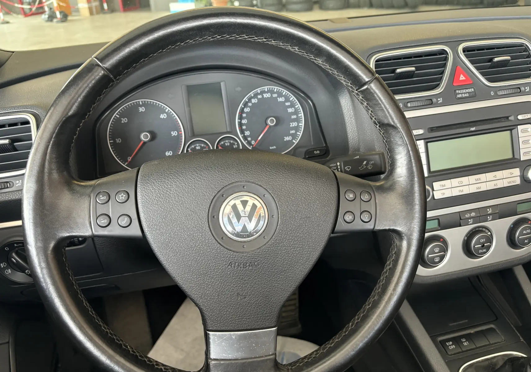 Vue intérieure centrée sur le volant noir de la Volkswagen EOS 2008 avec tableau de bord et console centrale visibles.