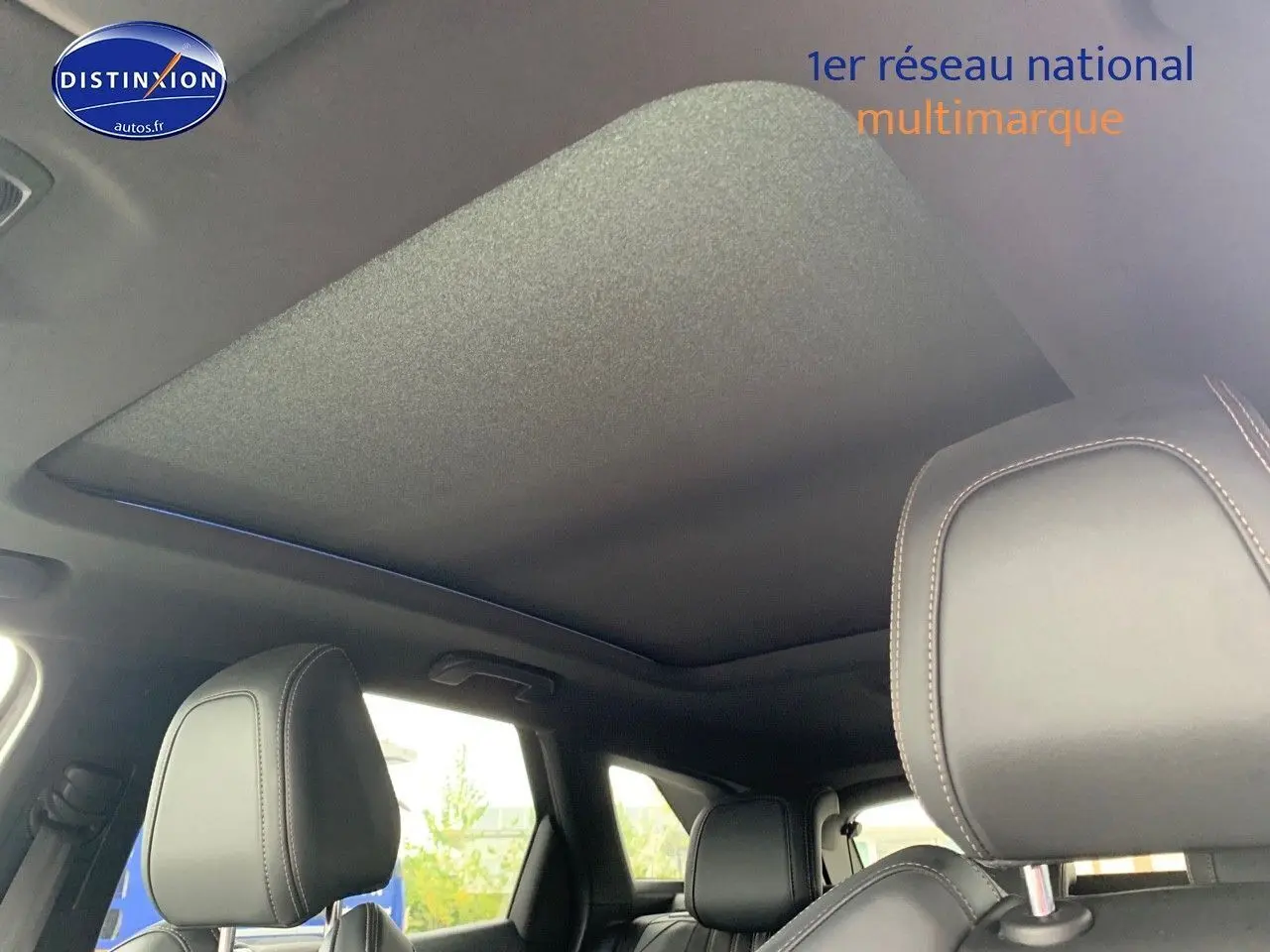 Toit panoramique fermé et sièges avant en cuir noir dans un Peugeot 3008 gris platinium, vue intérieure arrière.