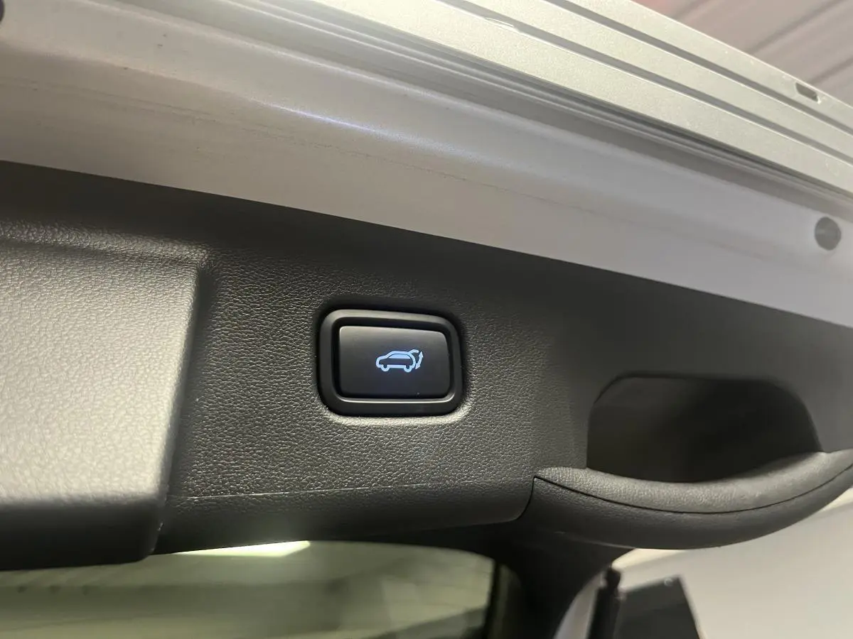 Bouton d'ouverture électrique du hayon sur le coffre d'un Hyundai Tucson gris 2023 hybride rechargeable.