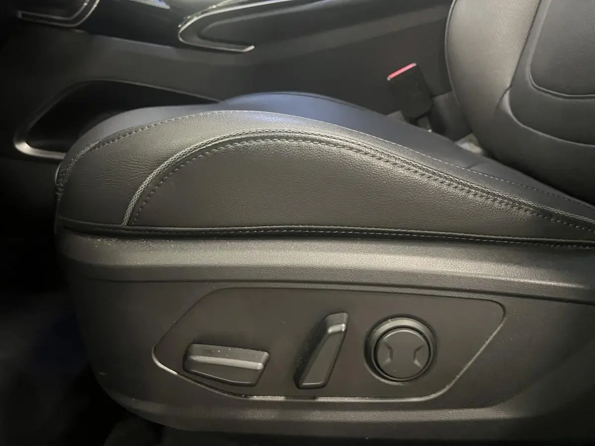 Détail des commandes de réglage électrique du siège conducteur en cuir noir dans un Hyundai Tucson gris 2023.