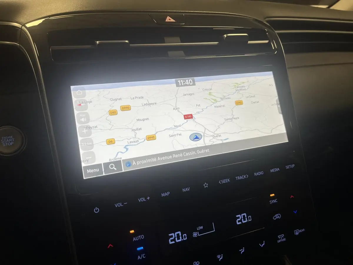 Écran tactile central du Hyundai Tucson gris 2023 affichant la navigation, vu de face en ambiance intérieure sombre.