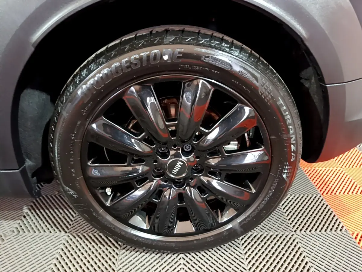 Gros plan sur la jante noire brillante du côté avant droit d'une MINI Countryman bleu 2021 hybride rechargeable.