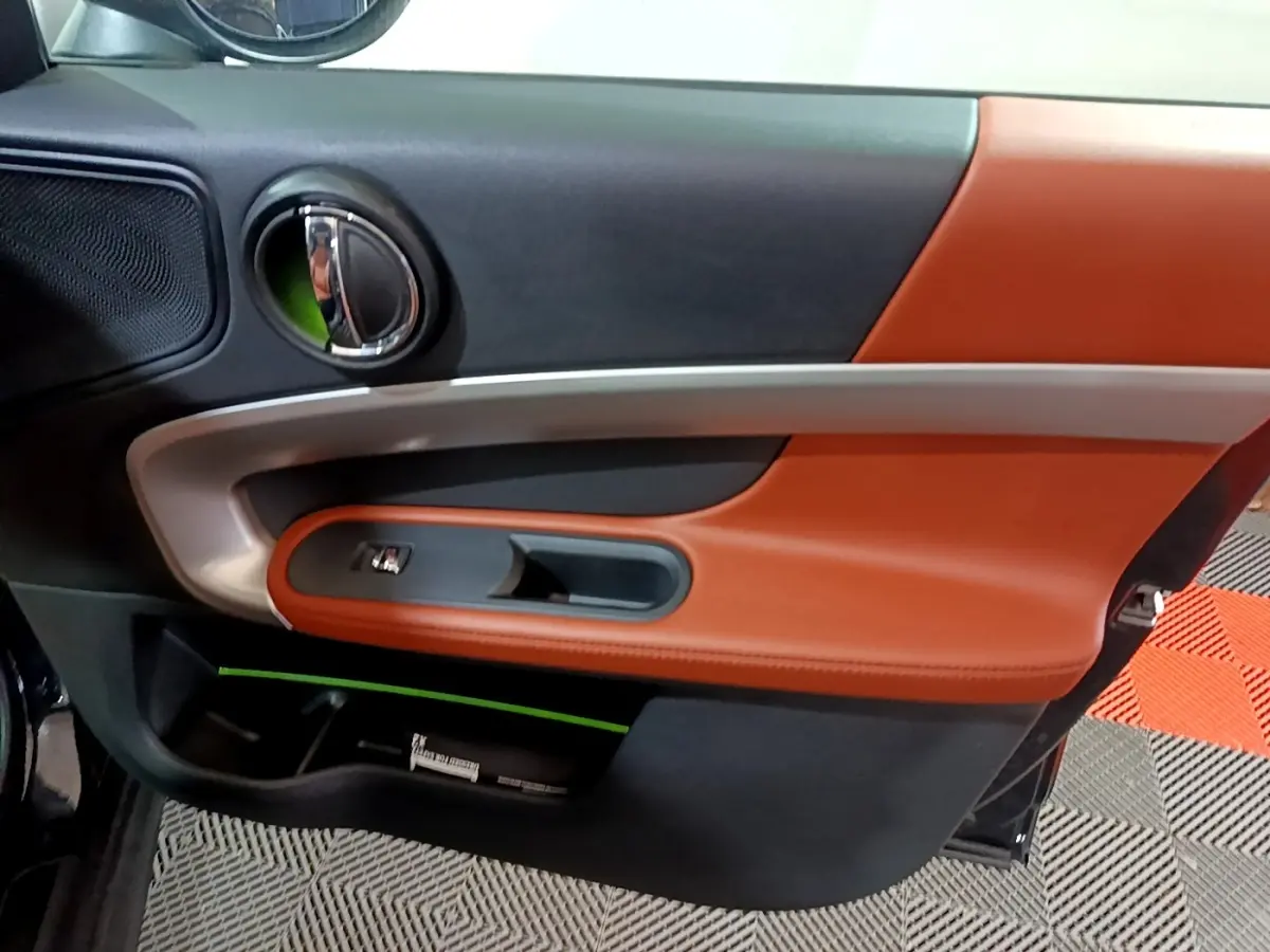 Gros plan sur la porte côté gauche du MINI Countryman 2021, avec garniture cuir marron et détails chromés.