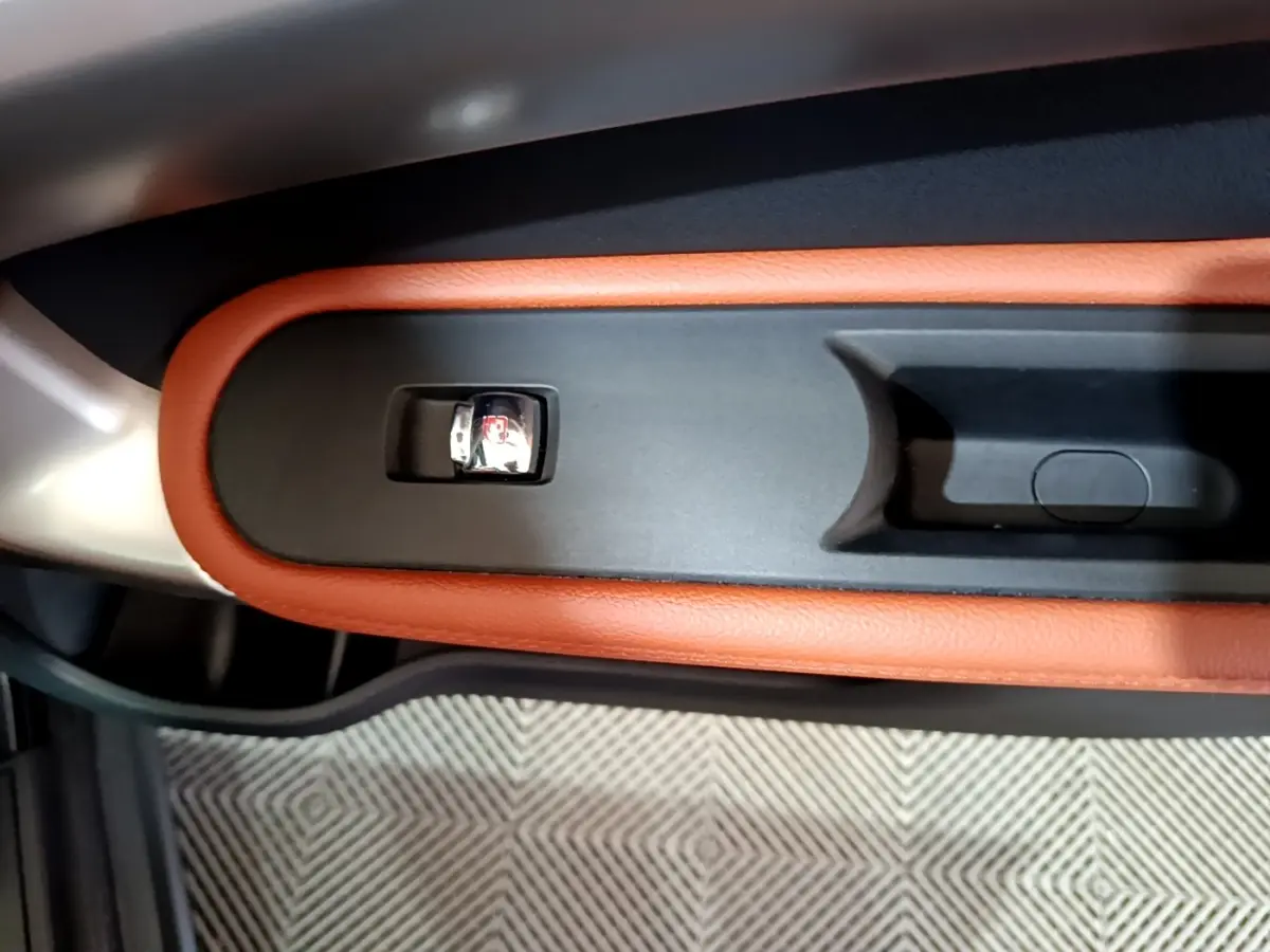 Détail de la poignée intérieure de porte avec garniture cuir marron sur MINI Countryman bleu 2021.