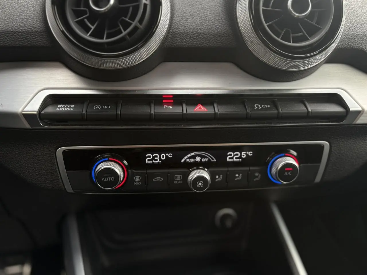 Vue rapprochée du tableau de bord de l’Audi Q2 35 TDI 150 S-Tronic S-Line, montrant la climatisation automatique bi-zone.