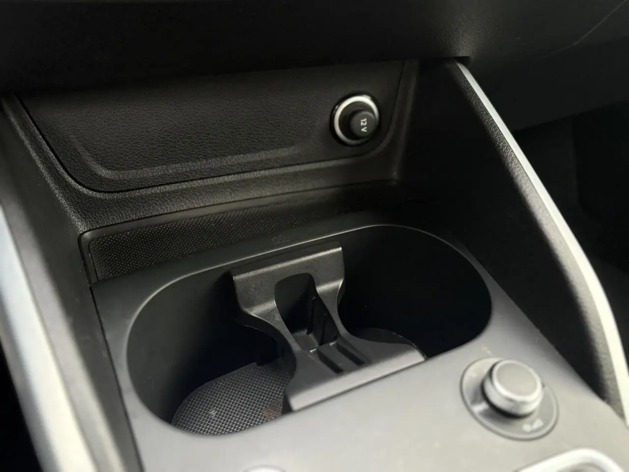 Gros plan sur le porte-gobelets central noir de l’Audi Q2 35 TDI 150 S-Tronic S-Line 2025, intérieur sombre.