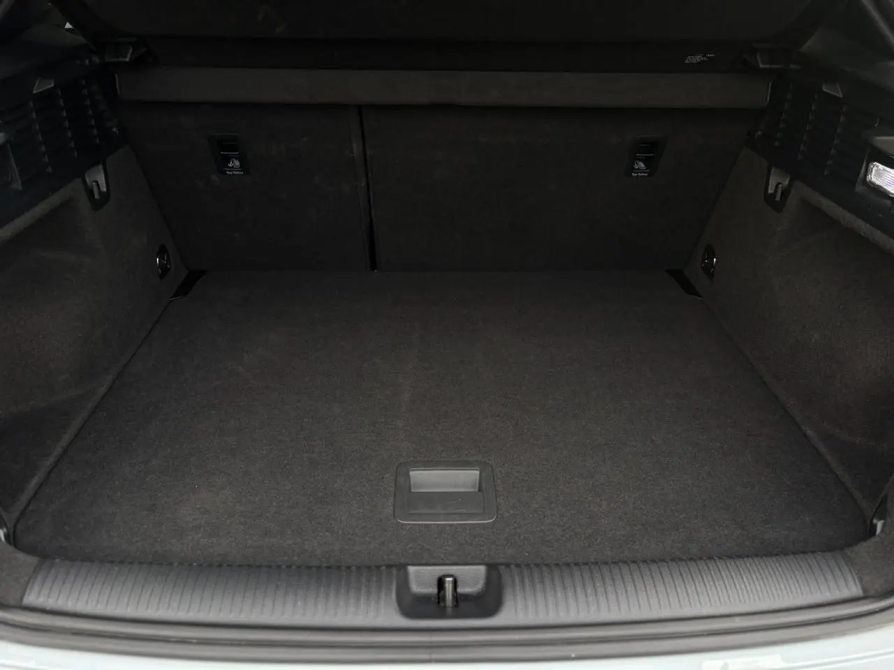 Coffre ouvert vu de l'arrière d'un Audi Q2 35 TDI S-Line gris Flèche, espace de chargement vide et propre.