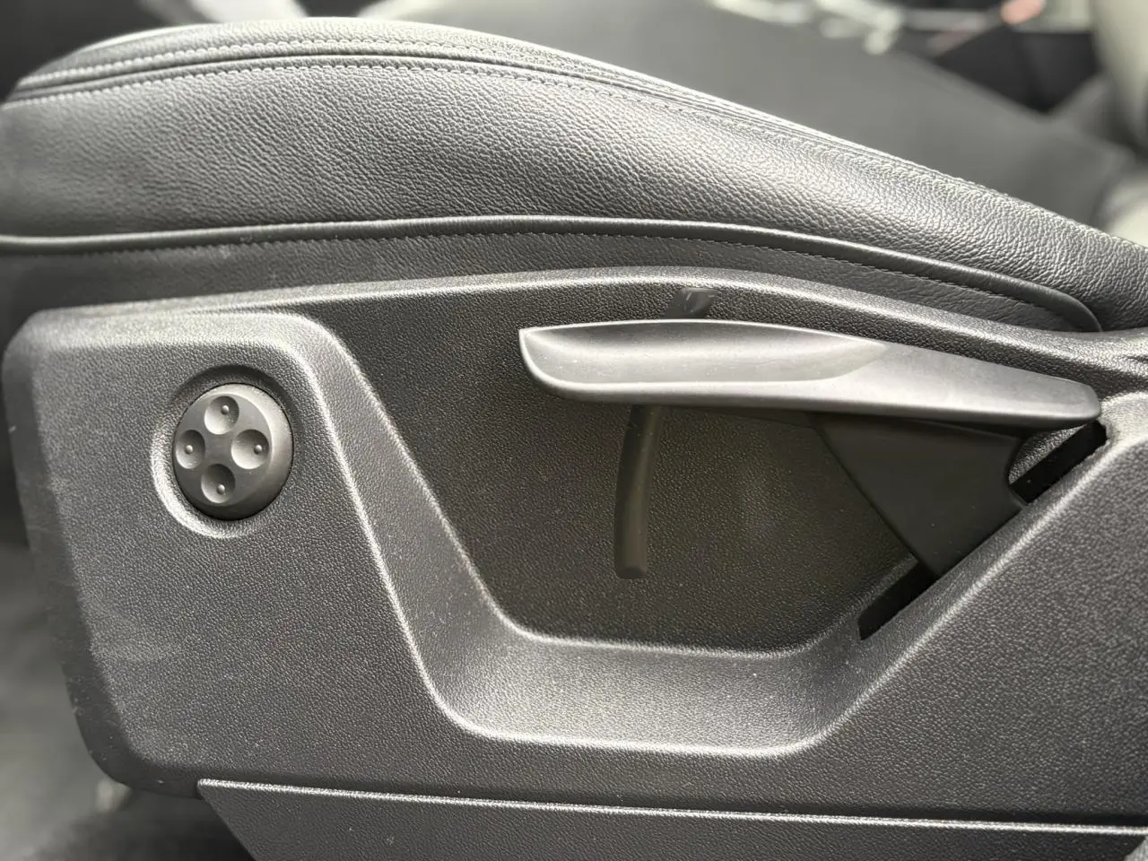 Détail du réglage manuel du siège avant en cuir noir de l'Audi Q2 35 TDI S-Line, côté gauche.