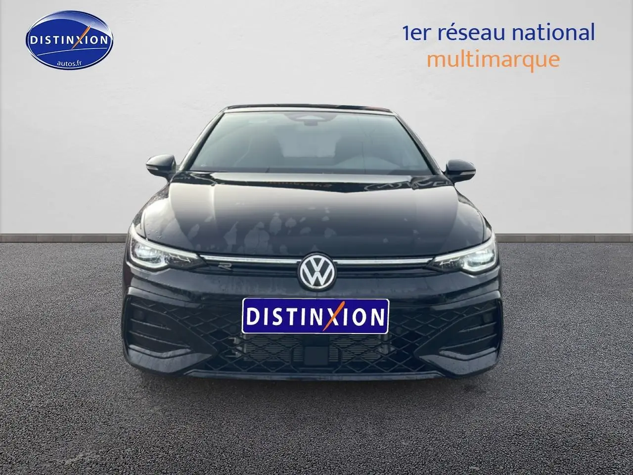 Vue avant d'une Volkswagen Golf noire 2026 avec calandre R-Line et phares LED allumés.