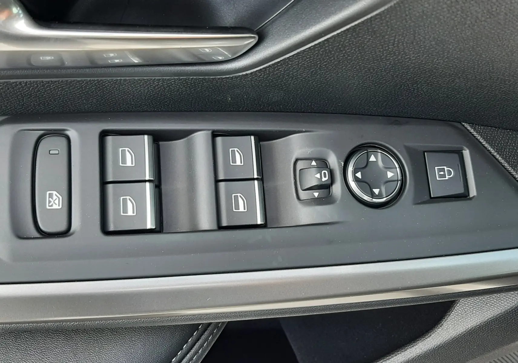 Gros plan sur la commande des vitres et rétroviseurs côté conducteur du Peugeot 3008 gris titane, finition GT.