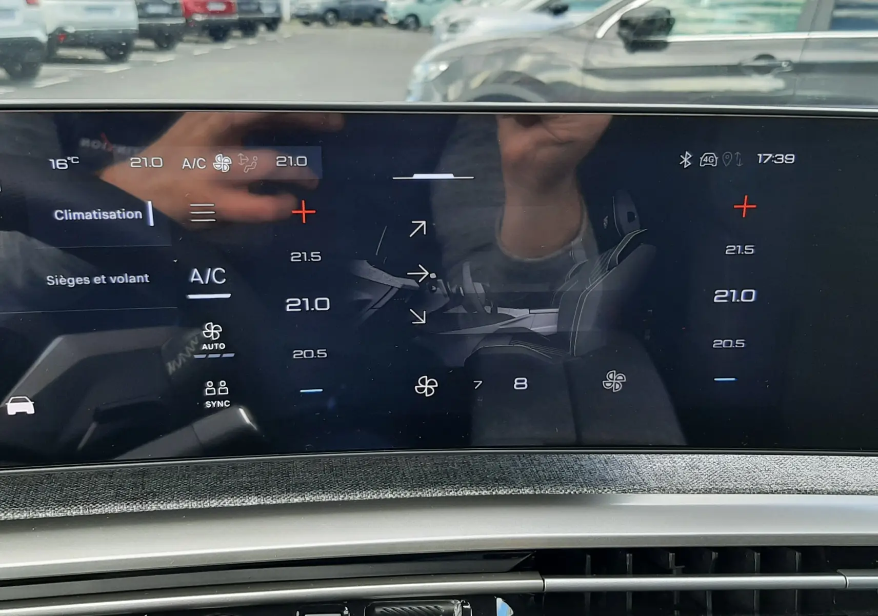 Vue intérieure sur l’écran tactile de climatisation du Peugeot 3008 gris titane, avec bouton start/stop et commandes modernes.