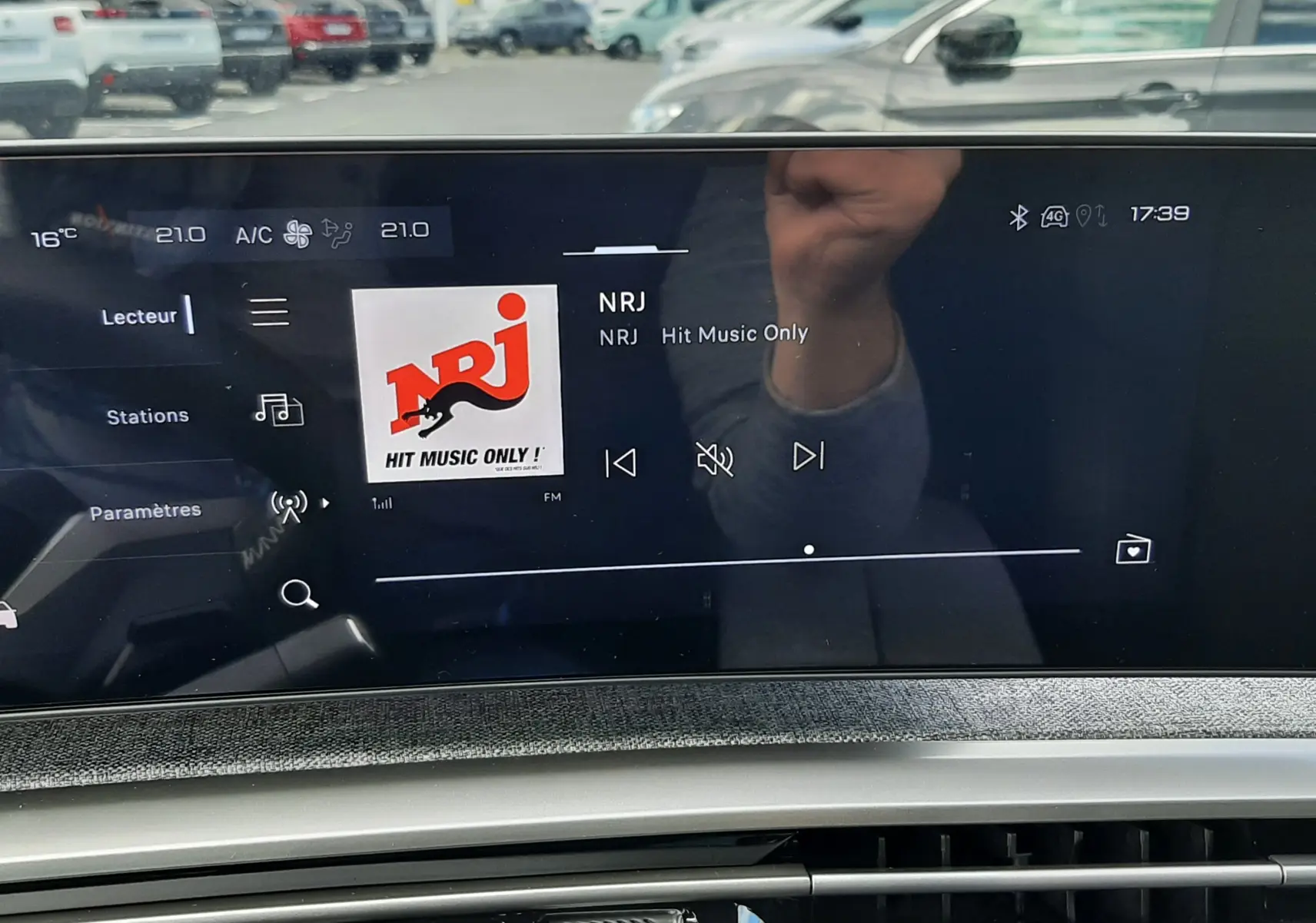 Vue rapprochée de l’écran multimédia et de la console centrale du Peugeot 3008 gris titane, affichant la radio NRJ.