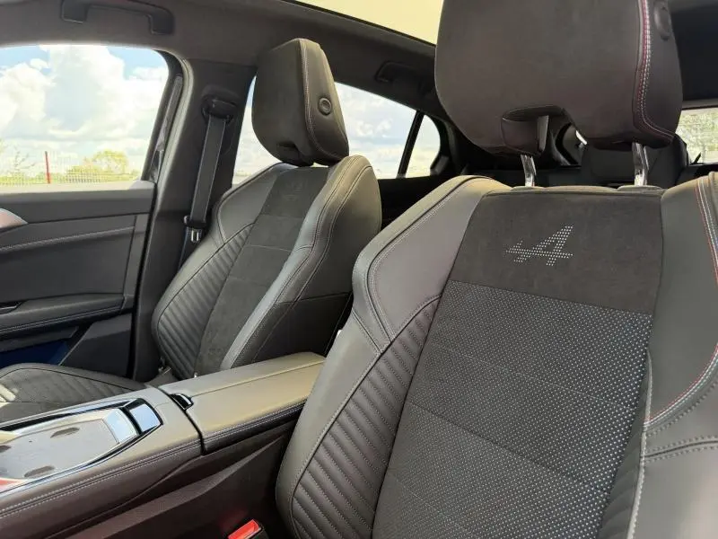 Vue intérieure rapprochée des sièges avant du Renault Rafale 1.2 E-Tech noir étoilé avec logo Alpine brodé sur l'appui-tête.
