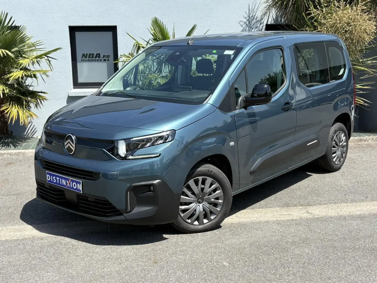 Citroën Berlingo ë-136 bleu Kiama en 3/4 avant droit, avec jantes tôles et calandre noire distinctive.