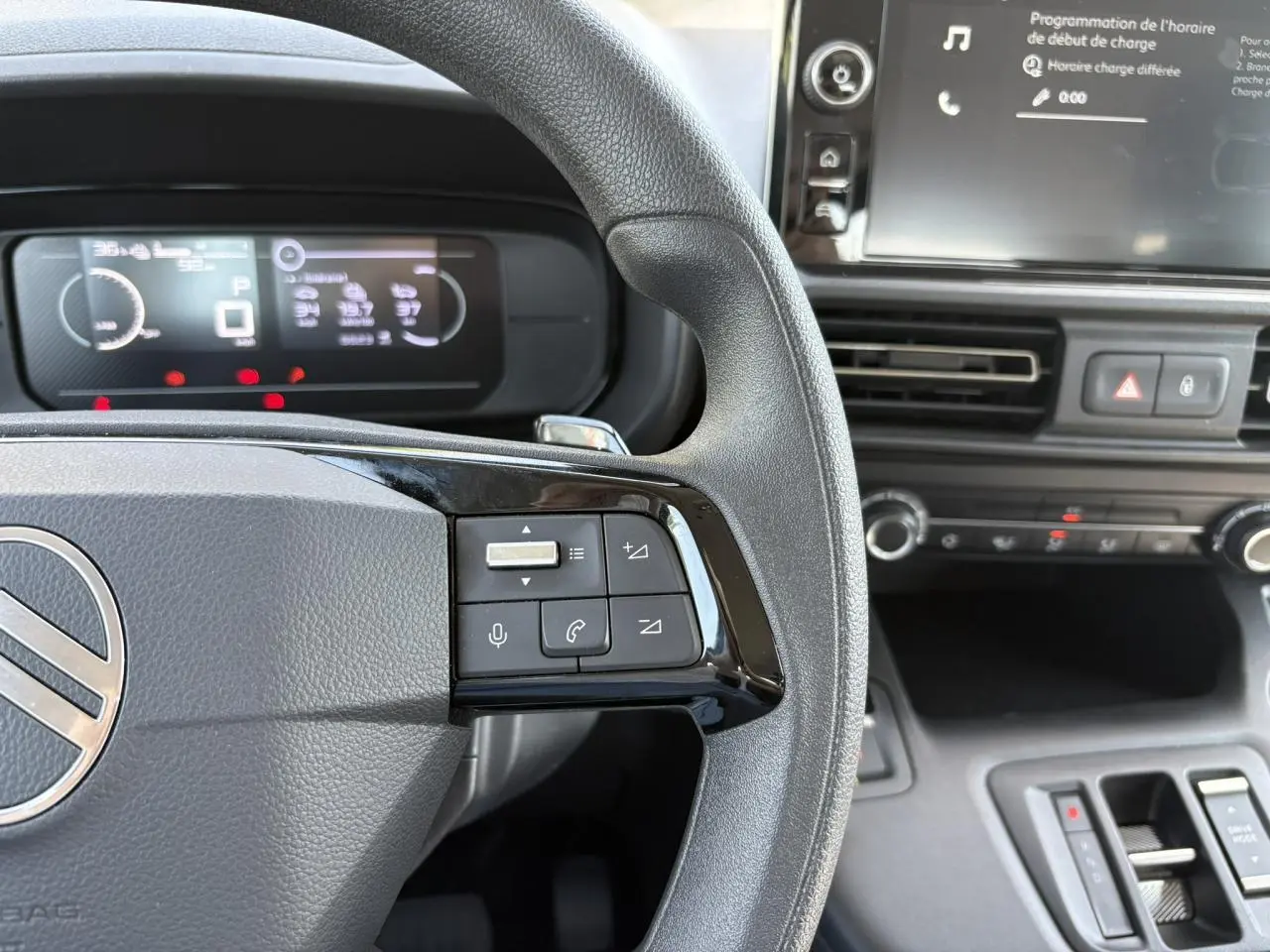 Vue rapprochée du volant multifonction et du tableau de bord numérique du Citroën Berlingo ë-136 2025, intérieur noir.
