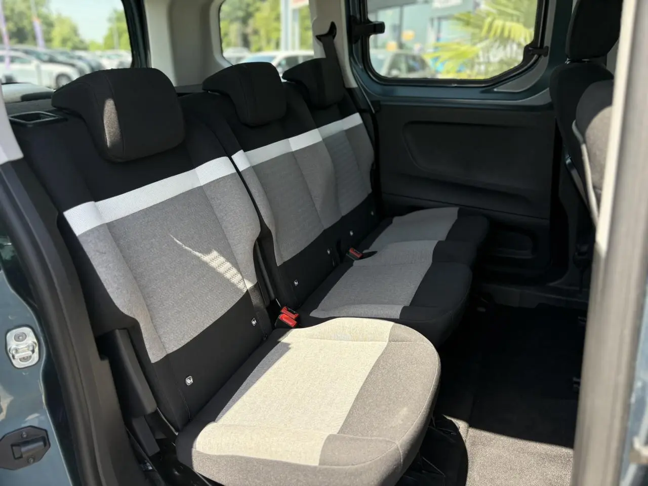 Vue intérieure côté droit sur la banquette arrière grise et noire du Citroën Berlingo ë-136 54kWh 2025.