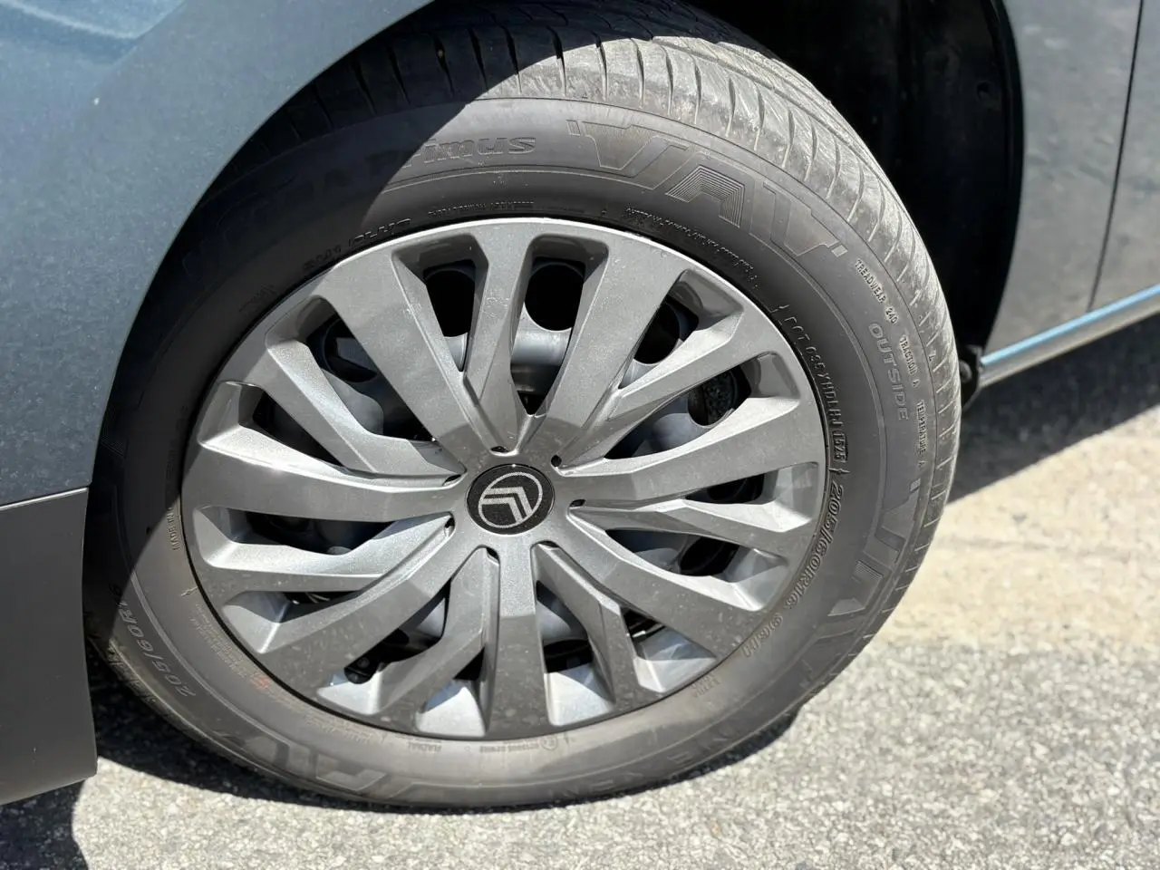 Gros plan sur la jante tôlée 16 pouces avec enjoliveur gris du côté avant droit du Citroën Berlingo Bleu Kiama.